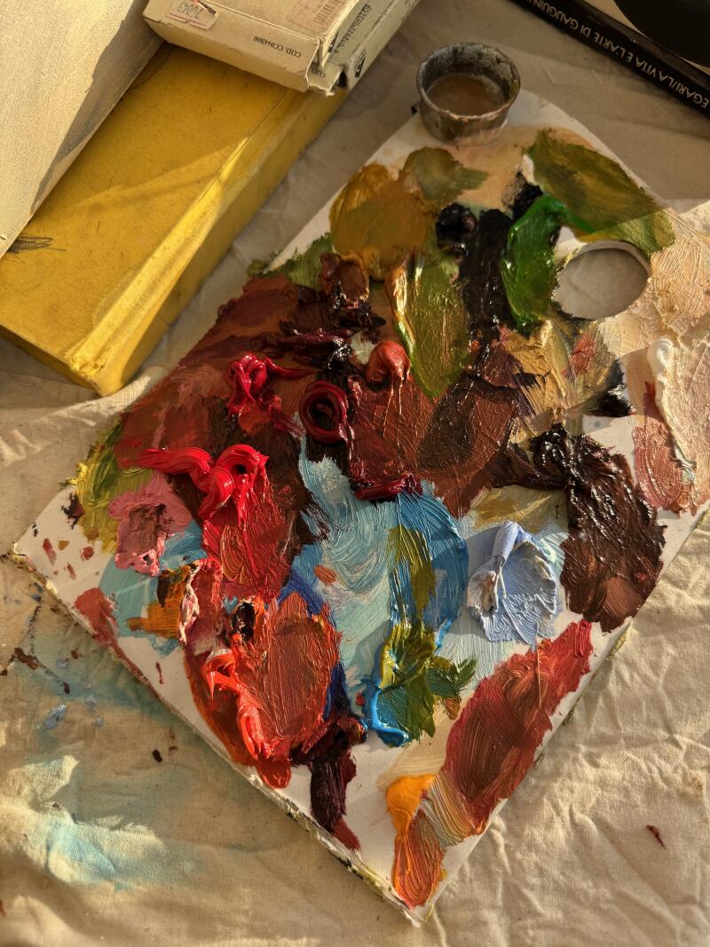 На изображении палитра с различными цветами масляной краски, включая красный, синий, зеленый, коричневый и желтый, а также маленький металлический контейнер, желтый блок и коробка с надписью 'COD.CCH4800'.