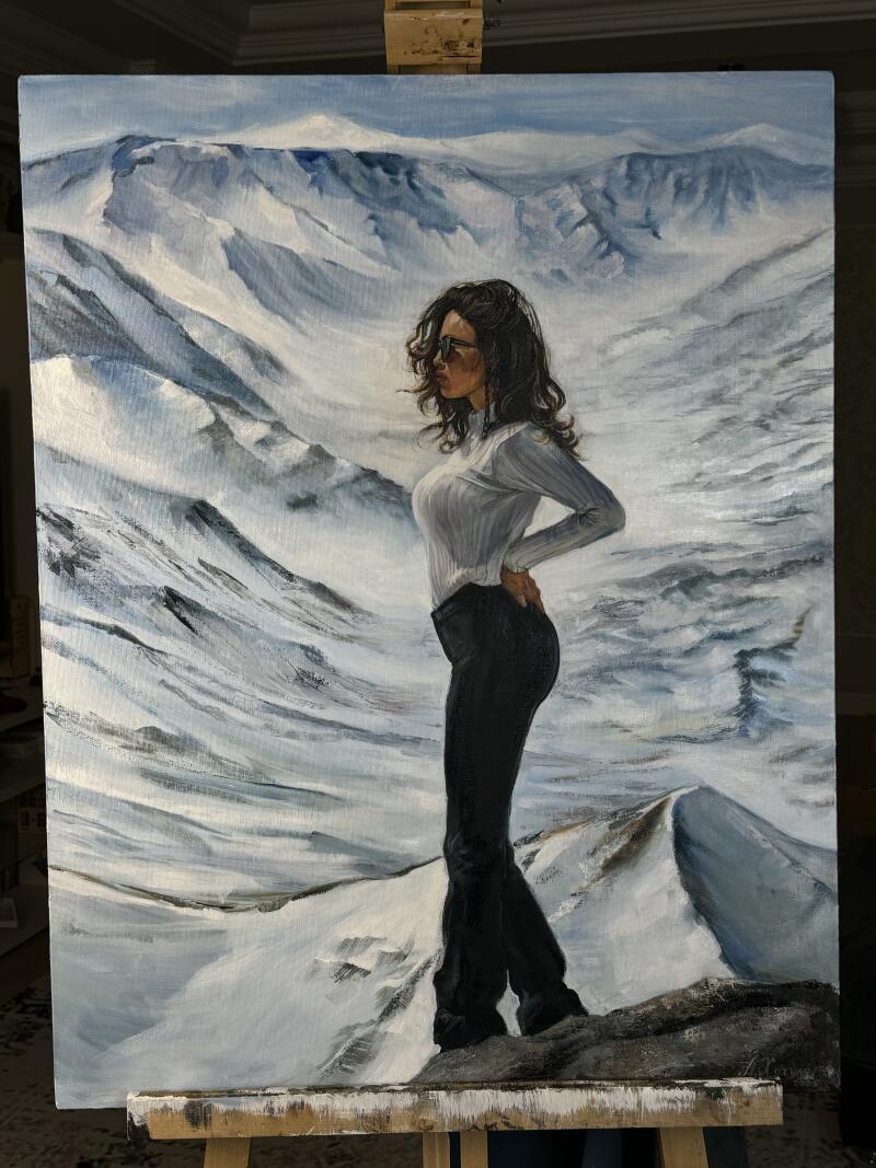 A painting depicts a woman in sunglasses, a white sweater, and black pants, standing on a rock in front of a snowy mountain range.