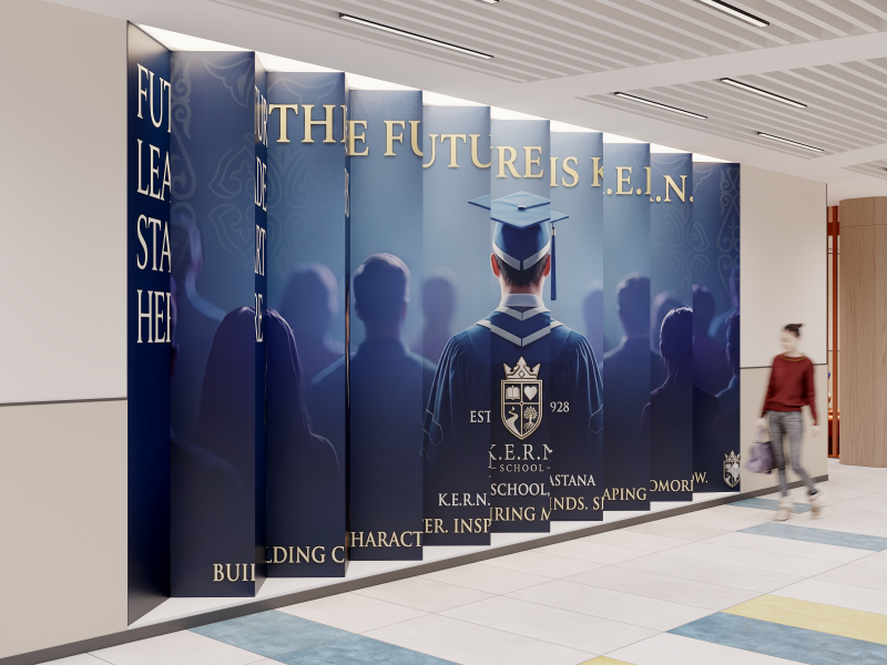 A series of vertical panels displays the text 'FUTURE IS K.E.R.N' above an image of a graduate in a blue gown, with the school's emblem and the words 'K.E.R.N. SCHOOL - ASTANA'. A person walks by in the background.