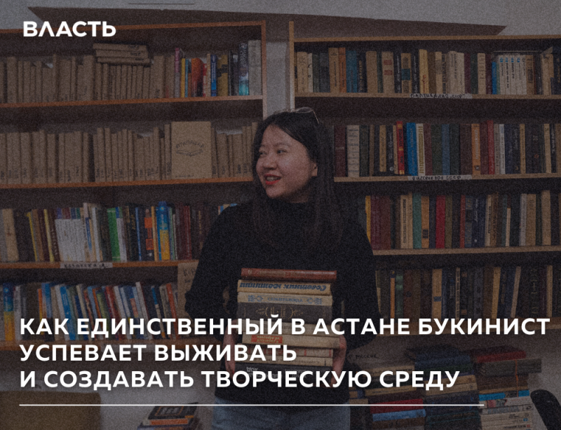 A woman smiles while holding a stack of books in front of a bookshelf, with text overlay that reads: "КАК ЕДИНСТВЕННЫЙ В АСТАНЕ БУКИНИСТ УСПЕВАЕТ ВЫЖИВАТЬ И СОЗДАВАТЬ ТВОРЧЕСКУЮ СРЕДУ" and "ВЛАСТЬ" in the upper left.